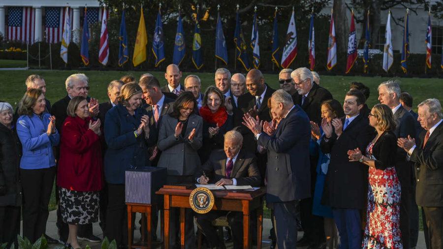 WASHINGTON%2C+DC+-+NOVEMBER+15%3A+U.S.+President+Joe+Biden+signs+the+Infrastructure+Investment+and+Jobs+Act+as+he+is+surrounded+by+lawmakers+and+members+of+his+Cabinet+during+a+ceremony+on+the+South+Lawn+at+the+White+House+on+November+15%2C+2021+in+Washington%2C+DC.+The+%241.2+trillion+package+will+provide+funds+for+public+infrastructure+projects+including+improvements+to+the+countrys+transportation+networks%2C+increasing+rural+broadband+access%2C+and+projects+to+modernizing+water+and+energy+systems.+%28Photo+by+Kenny+Holston%2FGetty+Images%29