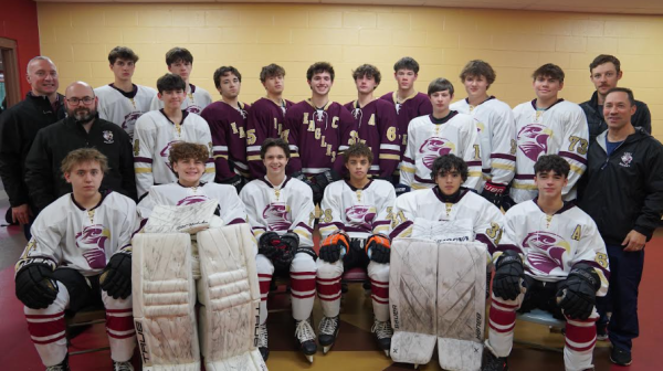 Wade Larson (center right) and the boys co-op ice hockey team poses before a game.