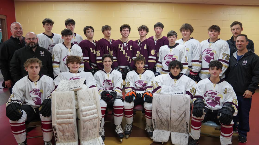 Wade Larson (center right) and the boys co-op ice hockey team poses before a game.