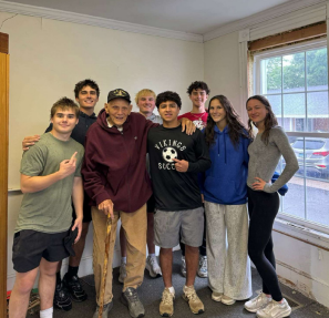 Members of the Vikings Play it Forward organization pose for a picture with Norm Higgins, owner of Connecticut Sporting Goods.